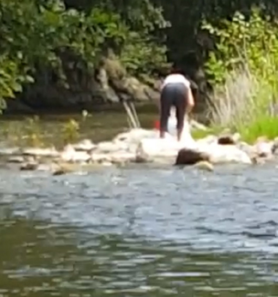 Žena baca smeće u reku