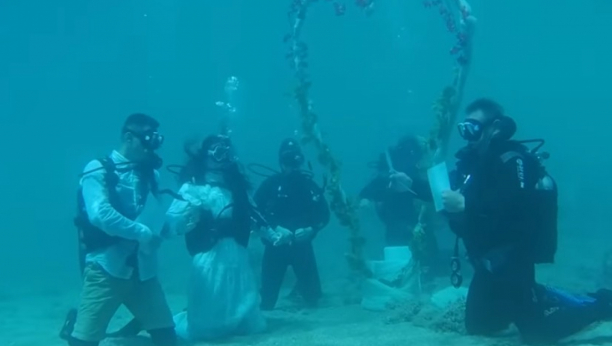 OVO JE NEČUVENO Par se venčao pod vodom, sa ronilačkom opremom, u odelu i sa matičarem, ljudi sa obale gledali i krstili se (VIDEO)