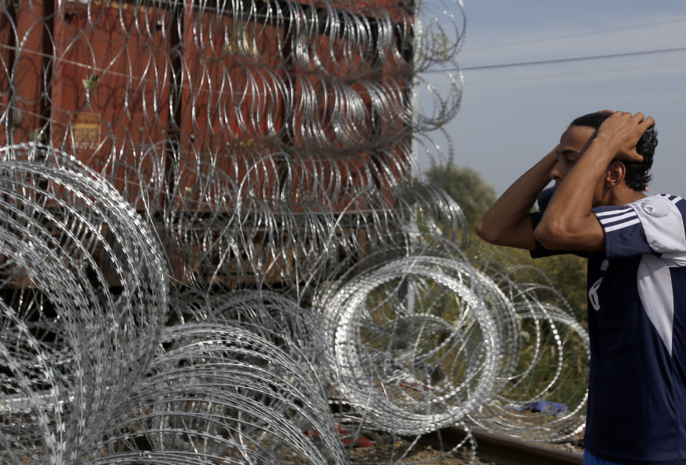 Izbeglica ispred ograde s bodljikavom žicom na granici Mađarske