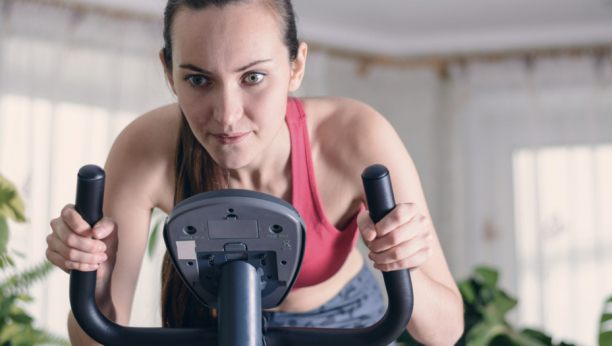 Žena vozi sobni bicikl