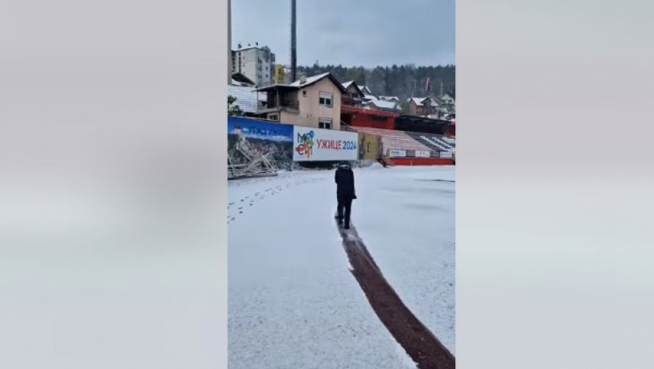 Trener čisti sneg na stadionu