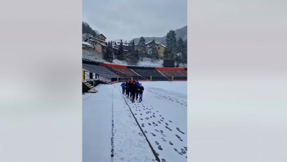 Trener čisti sneg na stadionu