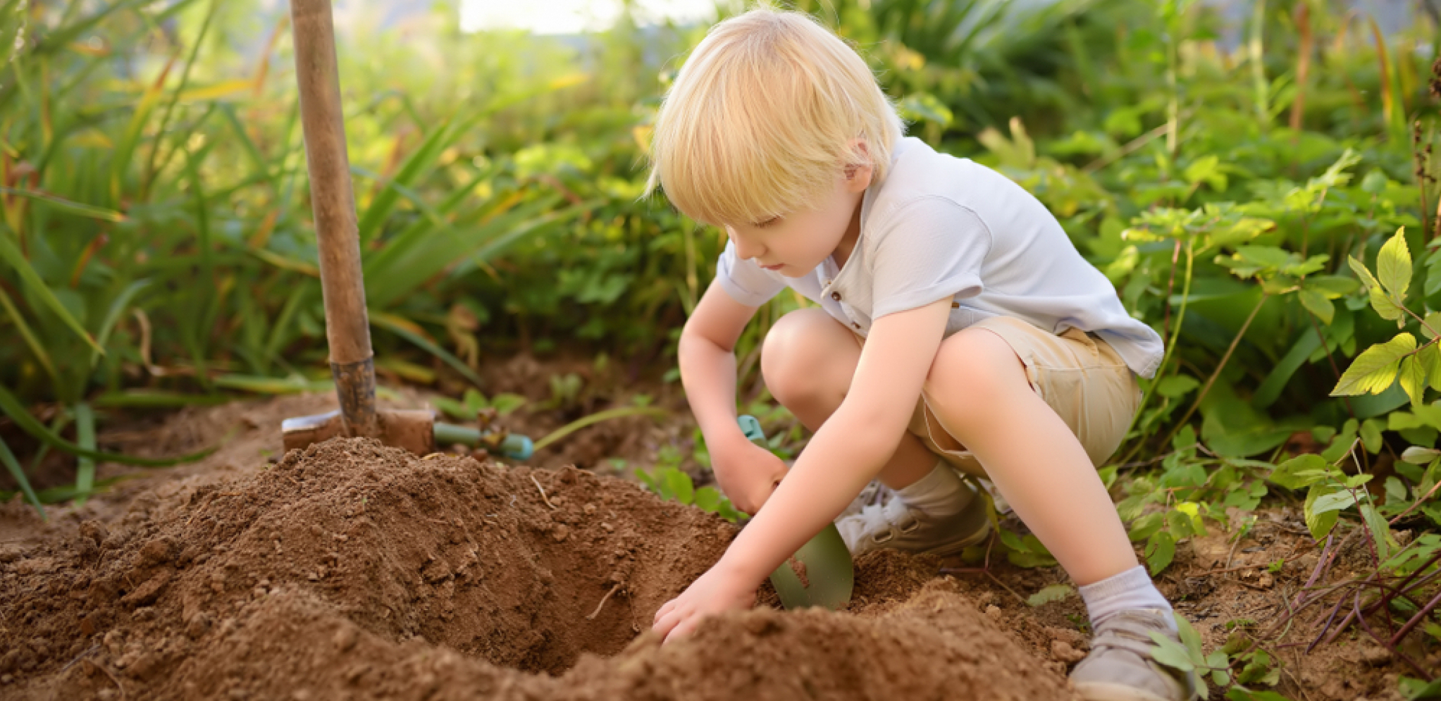 dečak kopa u bašti