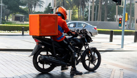 Dostavljač zatim brzo podiže posudu, vraća poklopac i – golom rukom ubacuje krilce nazad u kutiju