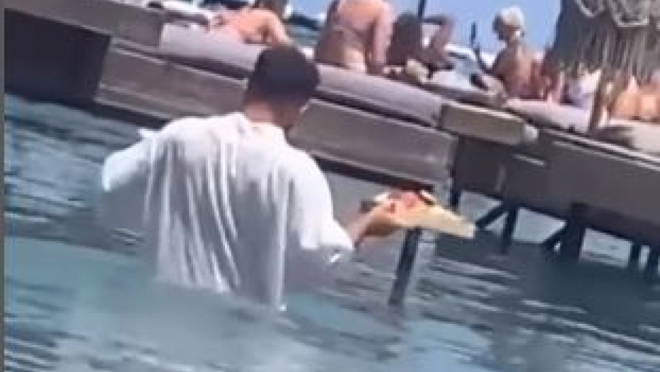 Snimak konobara koji nosi porudžbinu kroz duboku vodu pokrenuo raspravu na mrežama (VIDEO)